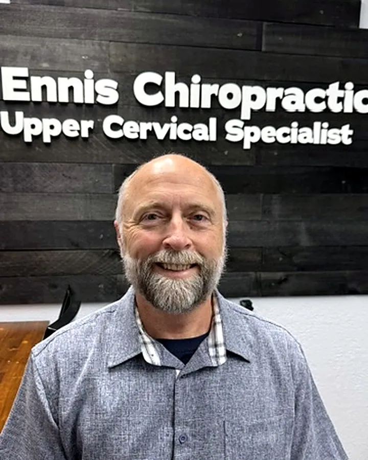 Dr. Michael Ennis in front of the Ennis Chiropractic Upper Cervical Specialist sign